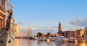 Vor Bremerhaven kreuzen Windjammer auf Hafen mit einem Segelschiff, Leuchtturm in der Abendsonne