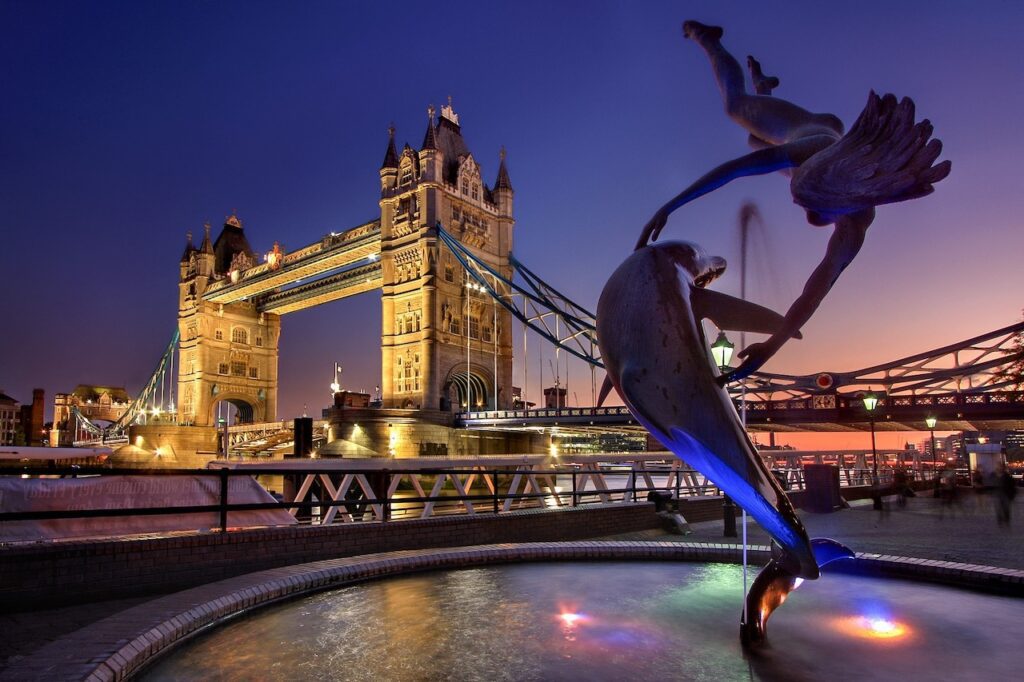 London Tower bei Nacht mit Brücke und einer modernen Plastik im Vordergrund