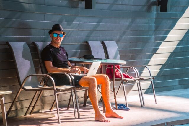 man-4749237_1920 workation 1280x853 Workation zwischen See und Berge: Mann mit Sonnenbrille, Hut, in kurzen Hosen mit Laptop auf seinen Beinen am Rand eines Pools