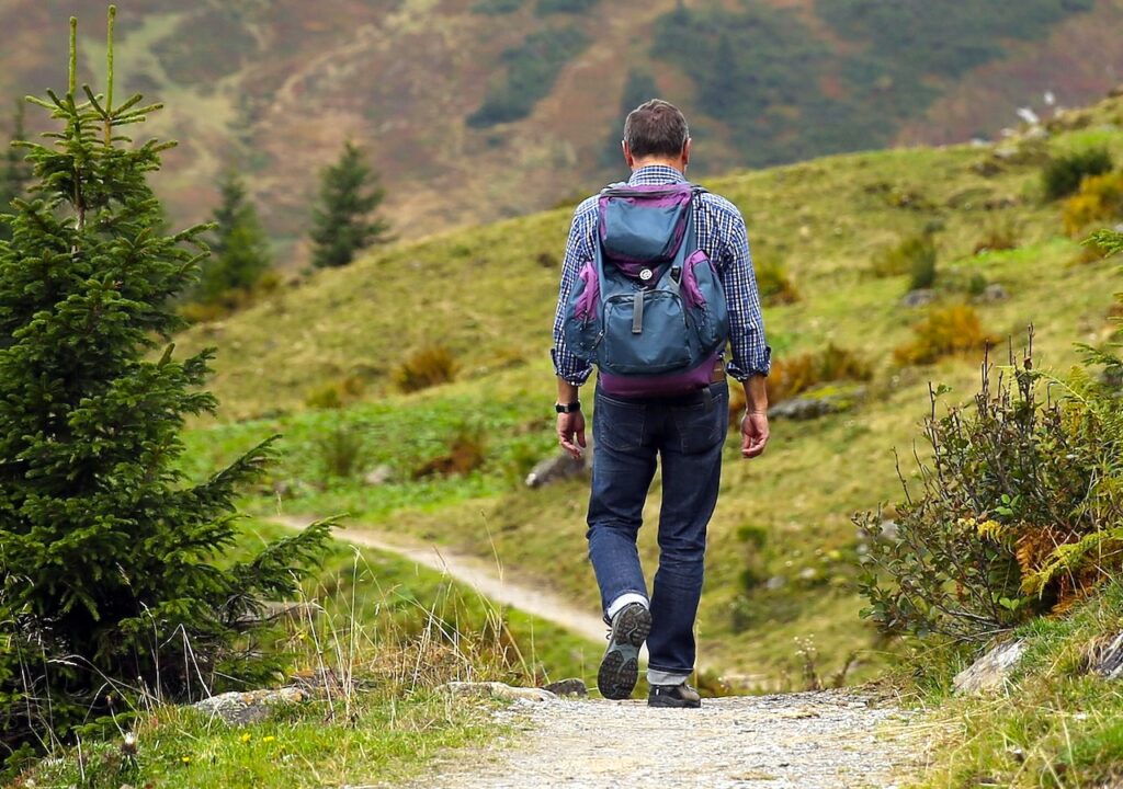 Bergurlaub abseits der Massen: Einsamer Wanderer mit Rucksack unterwegs in einer Alpenlandschaft