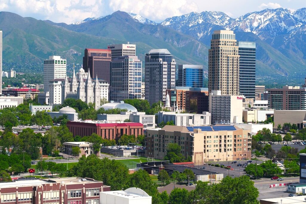 KLM und Salt Lake City mit Hochhäusern – umgeben von höhen schneebedeckten Bergen