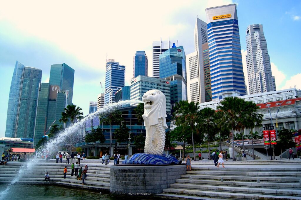 Wolkenkratzer in Singapore mit einem wasserspeienden Löwen im Vordergrund