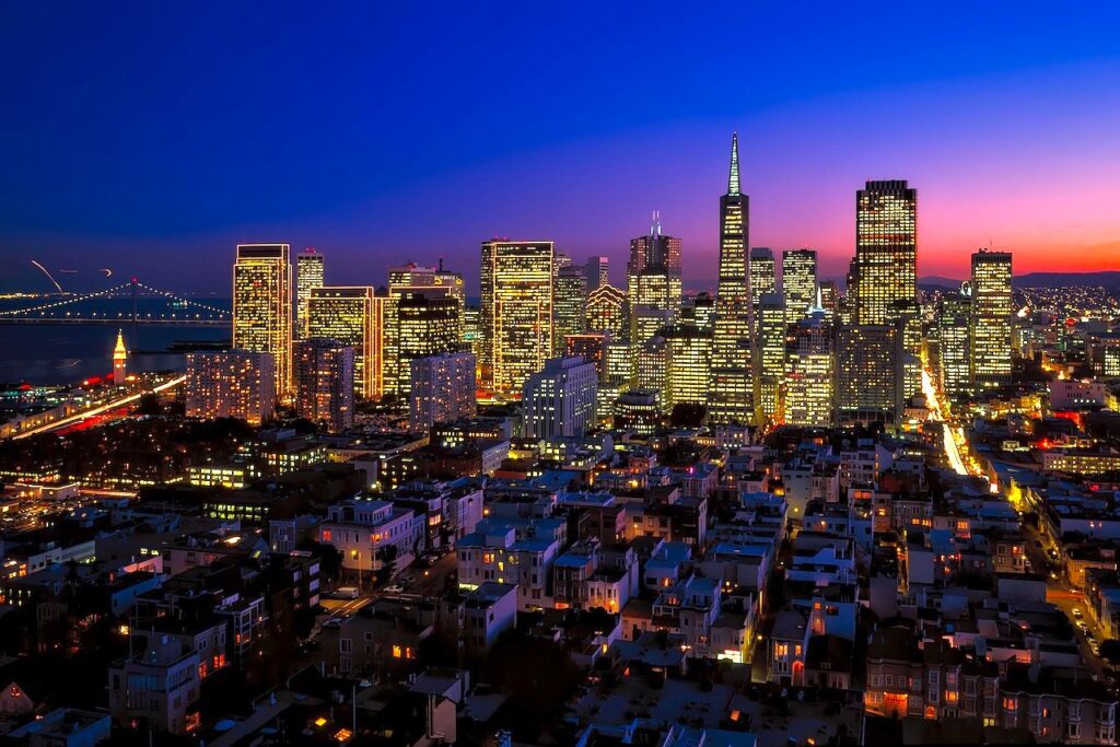 Nachtaufnahme von San Francisco mit beleuchteten Hochhäusern und der berühmten Transamerica Pyramide in der Mitte