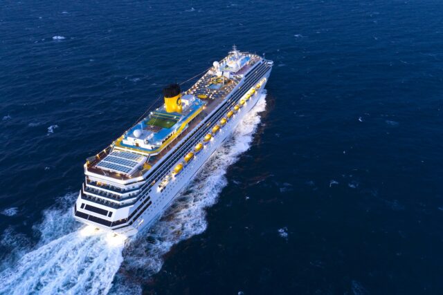 Das Costa Kreuzfahrtschiff Fortuna in voller Fahrt auf dem dunkelblauen Ozean