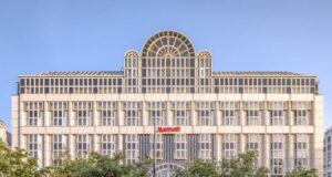 Vienna Marriott Hotel hat neuen Eigentümer Hotelfassade mit Kuppel auf dem Dach und mit Schrift Marriott, grüne Bäume davor