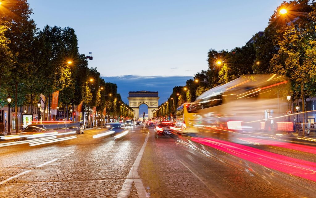 Reisemarkt in Europa: Paris gehört zu den beliebtesten Reisezielen. Lebhafte Nachtansicht. Der Champs élysées Mit Arc De Triomphe