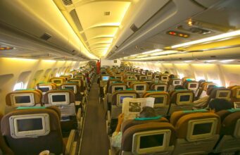 Warum Fliegen immer öfter Passagiere nervt Fliegen kann nerven: Beleuchtete Kabine in einem Flugzeug.