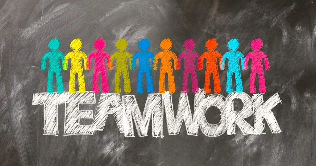 Richtige Veranstaltungsplanung. Eine Kreidetafel mitlitt vielen bunten gezeichneten Figure und darunter steht Teamwork