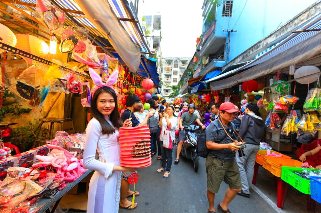 Asiatischer Markt, Asiatin bietet Lampion und kitschige Souvenirs an