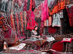 Verbotene Souvenirs lieber nicht kaufen! Geschäft mit vielen Teppichen, die von einer Frau in einer Ecke als Souvenirs angeboten werden