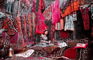 Verbotene Souvenirs lieber nicht kaufen! Geschäft mit vielen Teppichen, die von einer Frau in einer Ecke als Souvenirs angeboten werden