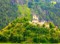 Österreich-Urlaub: Sichtbarkeit im Netz sinkt Österreich-Urlaub: Mittelalterliche Berg in einer grünen Landschaft mit bewaldeten Bergen und Hütten