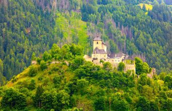 Österreich-Urlaub: Sichtbarkeit im Netz sinkt Österreich-Urlaub: Mittelalterliche Berg in einer grünen Landschaft mit bewaldeten Bergen und Hütten