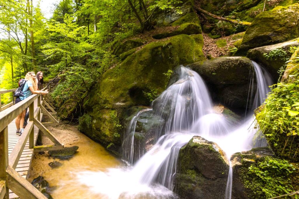 Donaregion m it Wolfsschlucht Bad Kreuzen, zwei junge Frauen beobachten von einem Holzsteg aus die Wasserkaskaden