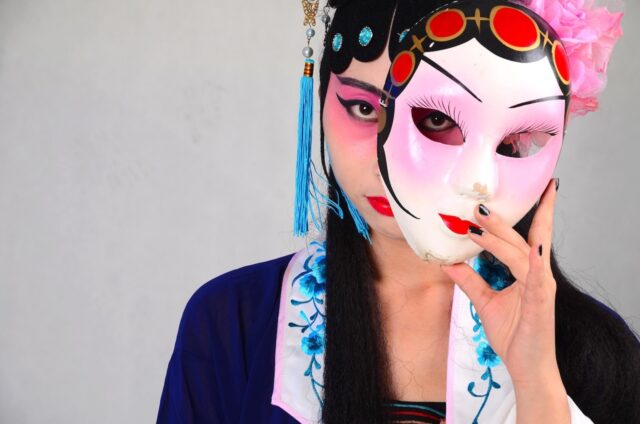 Visafreie Reise nach China: Oper in Peking, geschminkte Chinesin mit einer Turandot-Maske aus Porzellan