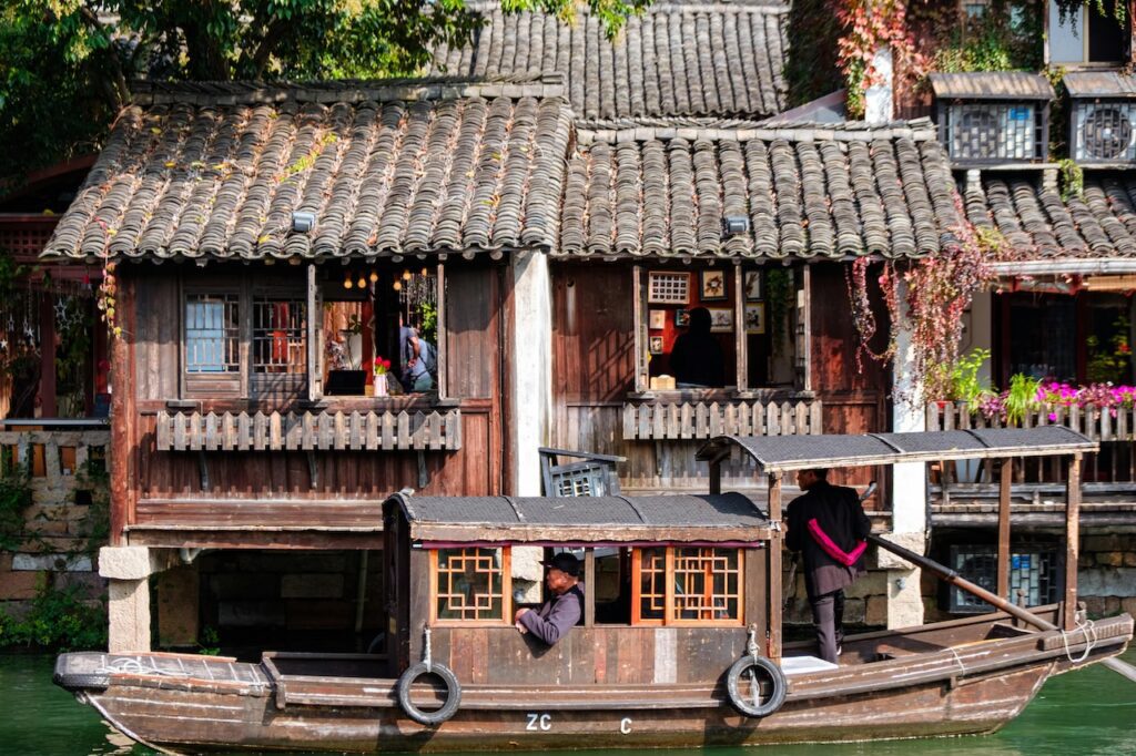 Visumfreie Reisen nach China. Typisches Holzhaus an einem Fluss im Reich der Mitte