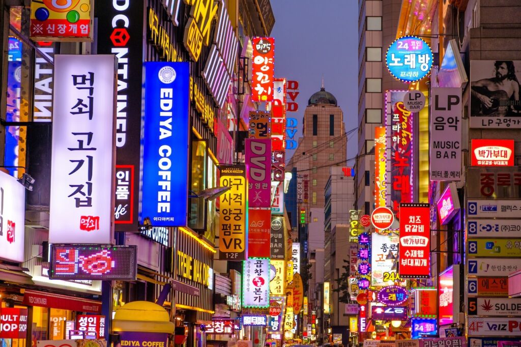 Eine Straße mit vielen Neon-Reklametafeln und zahllosen Geschäften und Restaurants