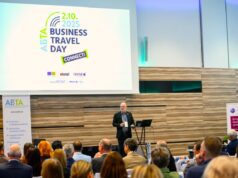 Business Travel Day Connect in Wien Connect Day: Ein Mann steht an einem Pult vor vielen Menschen und hält eine Rede. Im Hintergrund das Logo von ABTA eingeblendet