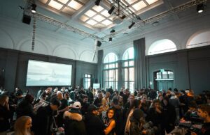 Hotels für Firmenevents richtig auswählen Ein Seminarraum mit Teilnehmer, die auf eine einen großen Bildschirm blicke