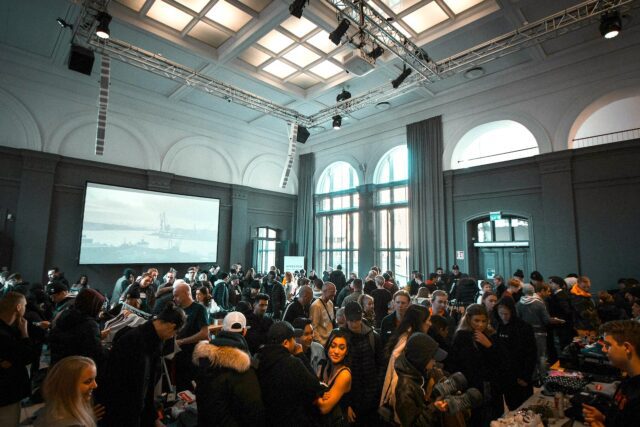 jakob-dalbjorn-cuKJre3nyYc-unsplash 1280x853 Ein Seminarraum mit Teilnehmer, die auf eine einen großen Bildschirm blicke