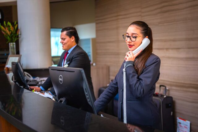 receptionists-5975962_1920 Businessreisen zufrieden mit Hotels? Zwei Rezeptionisten, eine Frau telefoniert, ein Mann blickt auf einen Bildschirm