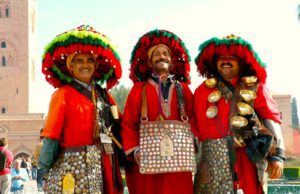 Mit Eurowings der Sonne entgegenfliegen Mit Eurowings nach Marrakesh: Drei Marokkaner in typischer Landestracht mit großen Hüten und goldenen Tassen behängt