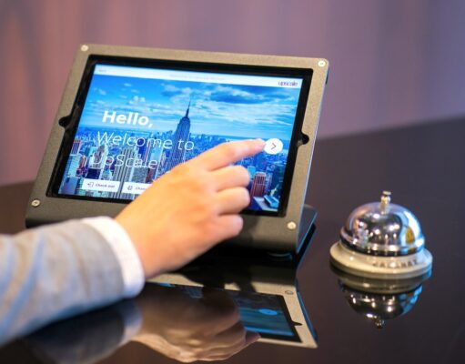 Wie werden Hotelprogramme gehandhabt? Studie über Hotelprogramme: Die Hand eines Mannes berührt den Bildschirm eines Tablets