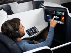 Apple TV auf Air France-Langstreckenflügen Flugreisender greift auf einem Bildschirm in einer Air France Maschine nach demApple TV Programm