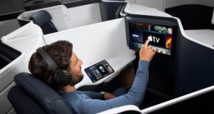 Apple TV auf Air France-Langstreckenflügen Flugreisender greift auf einem Bildschirm in einer Air France Maschine nach demApple TV Programm