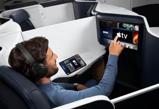 Apple TV auf Air France-Langstreckenflügen Flugreisender greift auf einem Bildschirm in einer Air France Maschine nach demApple TV Programm