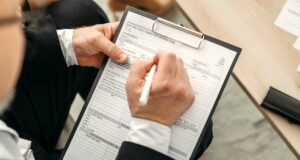 ehotel: Bestes Hotelportal für Unternehmen! ehotel als bestes Hotelportal ausgezeichnet: Mann schreibt Notizen auf einem Clip-Block
