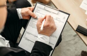 ehotel: Bestes Hotelportal für Unternehmen! ehotel als bestes Hotelportal ausgezeichnet: Mann schreibt Notizen auf einem Clip-Block