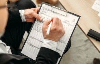 ehotel: Bestes Hotelportal für Unternehmen! ehotel als bestes Hotelportal ausgezeichnet: Mann schreibt Notizen auf einem Clip-Block