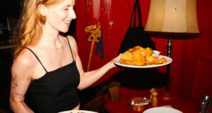 Hungry for more? Dann auf nach Wien! Hungry for more: Eine junge Frau serviert zwei Teller mit Fleischgerichten in einem Wiener Lokal