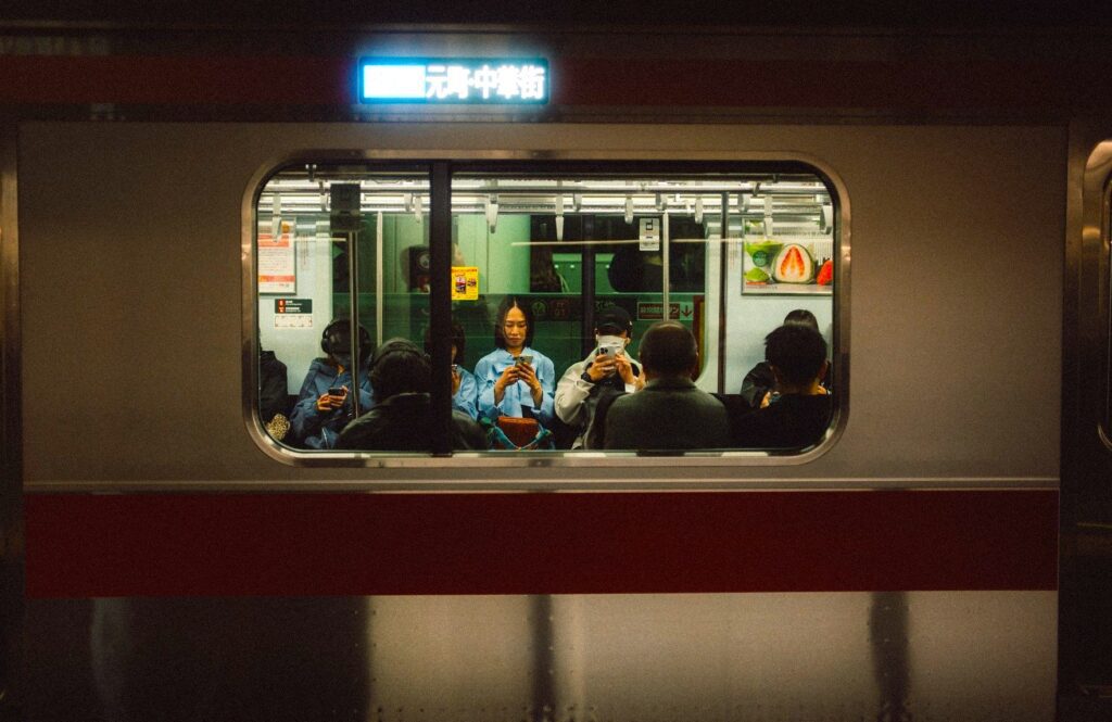 Japan: Blick in ein Zugabteil, wo Passagiere aufs Handy schauen