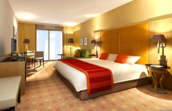 ehotel Top-Mittelstandsdienstleister in 2026 ehotel als bester Mittelstandsdienstgleiter in der Kategorie Hotelportl: Hotelzimmer mit roter Decke auf dem Bett mit angenehmer Beleuchtung