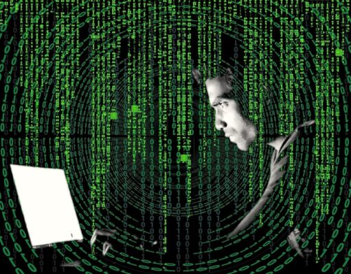 Reisebetrug ist die neue Gefahr für Urlauber Reisebetrug: Ein Mannsitzt vor einem Laptop, grüne Zeichen und Zahlen scrollen über ihn seinen Computerbildschirm