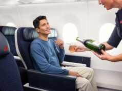 Air France erhöht das Reiseerlebnis in der Premium-Kabine Air France steigert das Reiseerlebnis in der Premium-Kabine: Ein sitzt im Flugzeug und eine Flugbegleiterin scheint ihm aus einer Flache Champagner ein