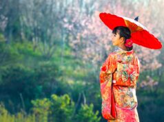 Einreise nach Japan mit neuen Bestimmungen Einreise nach Japan: Junge Frau mit Kimono und rotem Papiersonnenschirm