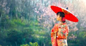 Einreise nach Japan: Neue Bestimmungen Einreise nach Japan: Junge Frau mit Kimono und rotem Papiersonnenschirm