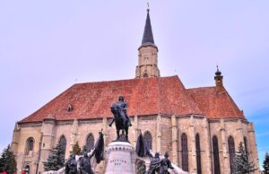 Mit AnimaWings nonstop von Wien nach Cluj Cluj AnimaWings nonstop von Wien erreichbar: Hauptkirche in der Altstadt von Cluj mit historischer Reiterstatue