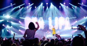 Eventmarkt: Deutschland bleibt weltweit Top Eventmarkt: Musikveranstaltungen, Scheinwerfer und eine Frau winkt zur von Spots angestrahlten Bühne