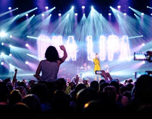 Eventmarkt: Deutschland bleibt weltweit Top Eventmarkt: Musikveranstaltungen, Scheinwerfer und eine Frau winkt zur von Spots angestrahlten Bühne