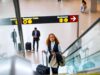 Kerosin-Debatte irritiert Geschäftsreisende Verwirrung rund um die Kerosin-Debatte: Frau mit Trollen auf einer Rolltreppe in einem Flughafen