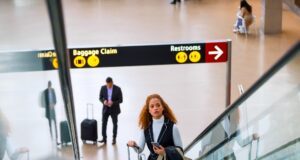 Kerosin-Debatte irritiert Geschäftsreisende Verwirrung rund um die Kerosin-Debatte: Frau mit Trollen auf einer Rolltreppe in einem Flughafen