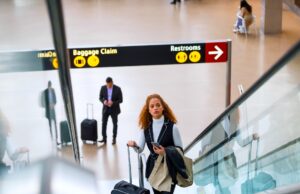 Kerosin-Debatte irritiert Geschäftsreisende Verwirrung rund um die Kerosin-Debatte: Frau mit Trollen auf einer Rolltreppe in einem Flughafen