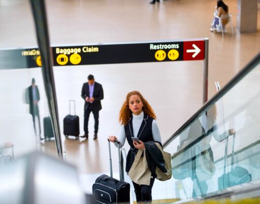 Kerosin-Debatte irritiert Geschäftsreisende Verwirrung rund um die Kerosin-Debatte: Frau mit Trollen auf einer Rolltreppe in einem Flughafen