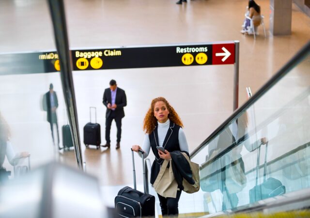 Verwirrung rund um die Kerosin-Debatte: Frau mit Trollen auf einer Rolltreppe in einem Flughafen