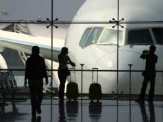 Geschäftsreisen: Die wichtigsten Key Insights Wie wichtig sind Geschäftsreisen wirklich? Eine Frau mit Handgepäck blickt von der Abflughalle durch einen großes Fenster auf ein Flugzeug