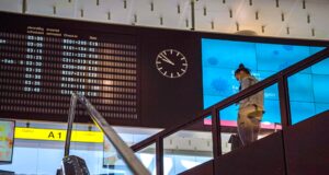EU-Fluggastrechte stärken Passagierrechte EU.Fluggastrechte gesichert: Anzeigetafel auf einem Flughafen, eine Person steigt eine Treppe herab